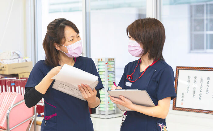 書類を確認しながら話す看護スタッフ