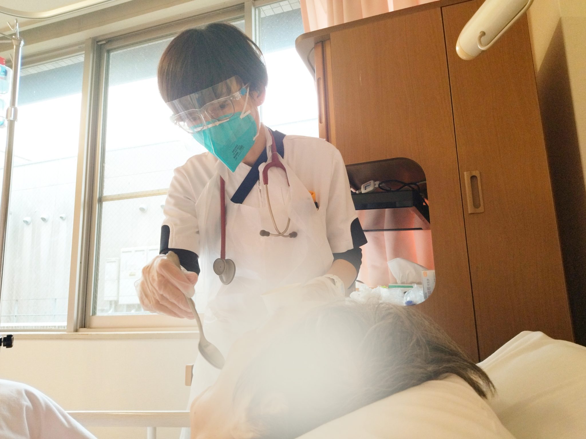 療法士が利用者に表情カードを示す様子