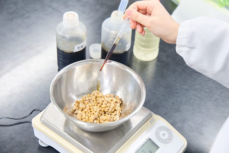 公式研究開発ページに掲載された納豆を扱う研究作業